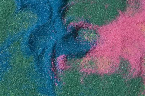 Close up of pastel coloured sand splashed red  background. Stock-Fotos