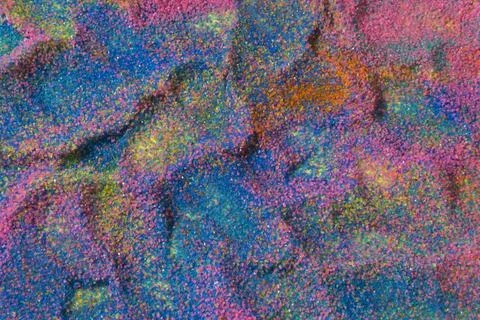 Close up of pastel coloured sand splashed red  background. Stock-Fotos
