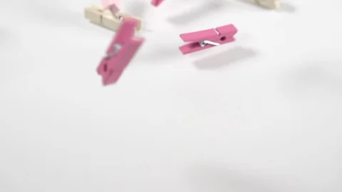 Close up of pastel craft pegs bouncing onto a white surface background, macro Stock Footage 89188998