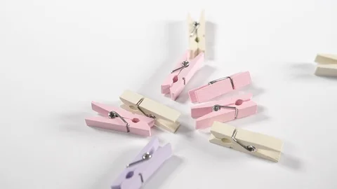 Close up of pastel craft pegs dropping onto a white surface background, macro Stock Footage 89189141