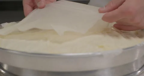 Close-up pastry chef arrange phyllo dough sheets on a round tray. Turkish Stock Footage 294246982
