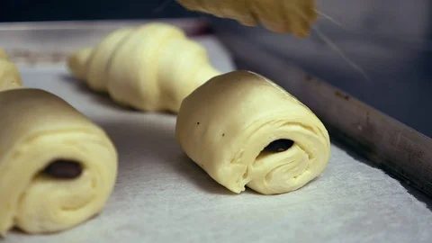 Close up pastry chef brushing egg wash on pain au chocolat chocolate Stock Footage 113846741