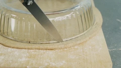 Close-up of a pastry chef cuts a round shape from a biscuit dough for a cake Video stock 136182211