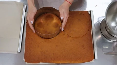 Close-up of a pastry chef cuts a round shape from a biscuit dough for a cake. Stock Footage 146315362