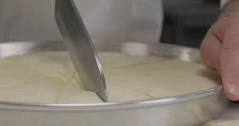 Close-up pastry chef cutting raw baklava in a tray. Turkish dessert baklava Stock Footage 293844500
