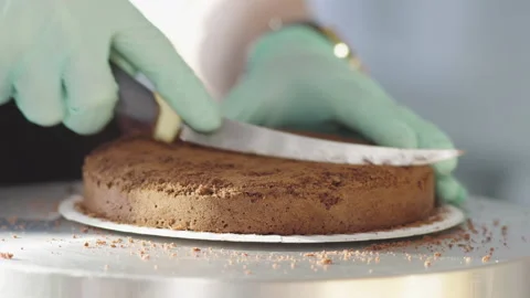 Close-up, pastry chef in Gloves cuts Cork with cake Stock Footage 136337993