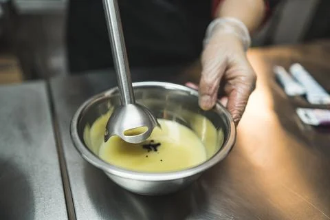 Close-up of a pastry chef mixing icing with food coloring with a hand blender Stock Photos