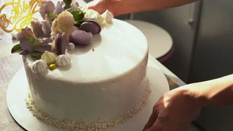Close-up of a pastry chef pouring liquid chocolate from a spoon on a white cream Stock Footage 166366005
