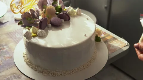 Close-up of a pastry chef pouring liquid chocolate from a spoon on a white cream Stock Footage 203839797