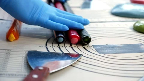 Close-up of a pastry chef rolling out soft caramel on a table in a pastry shop. Stock Footage 333246460