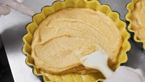 Close-up of a Pastry Chef Spreading Smooth Custard Filling into a Fluted Tart Sh Stock Footage 337751194
