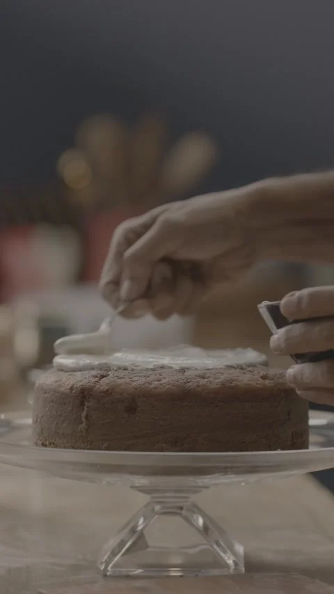 Close-up of a pastry chef spreading white cream on a chocolate cake. Stock-Footage 330155247