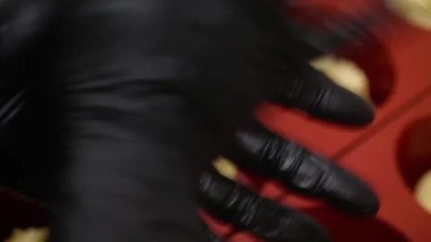 Close-up of Pastry Chef's Hands in Black Gloves Preparing Dessert Pies in Red Si Stock Footage 337751549