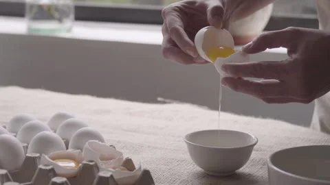 Close up, pastry Hands cracks the egg in the corner of a small bowl Stock Footage 240665199