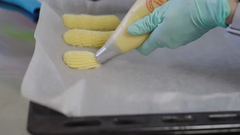 Close-up, Pastry Hands in Gloves Squeezed Out of Eclair Dough Package Stock Footage 136880973