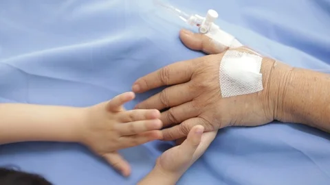 Close up Patient hand in bed with one hand being hold Stock Footage 100660027