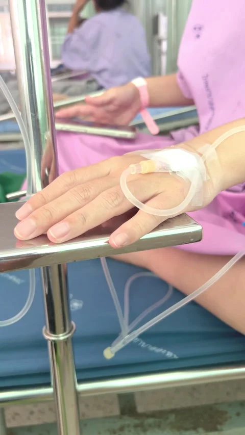 Close Up Patient Hand with Normal Saline IV Drip During Medical Treatment Care Stock Footage 328307122