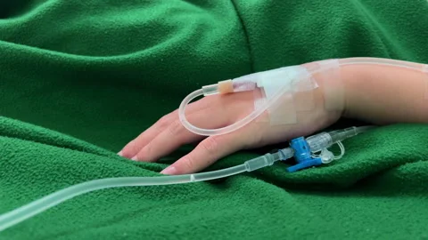 Close Up Patient Hand with Normal Saline IV Drip During Medical Treatment Care Stock Footage 328307185