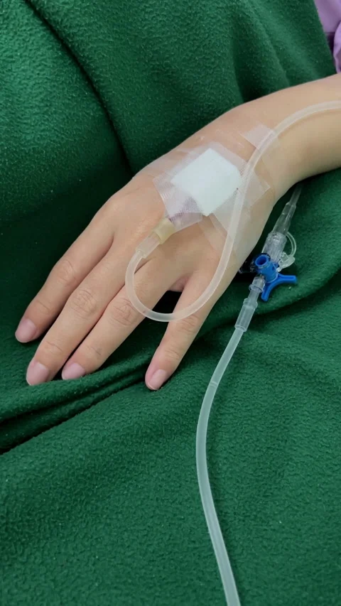 Close Up Patient Hand with Normal Saline IV Drip During Medical Treatment Care Stock Footage 328307186