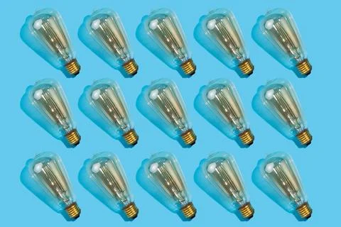 Close up pattern of edison lamps on an isolated blue background. Energy effic Stock Photos