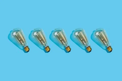 Close up pattern of edison lamps on an isolated blue background. Energy effic Foto stock
