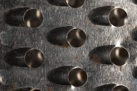 Close-up pattern of the holes of an old kitchen grater with rust elements Foto stock