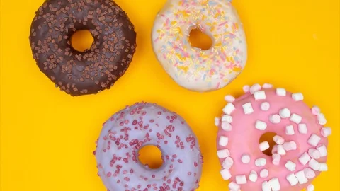 Close up pattern of sweet donuts rotating and moving on the table. Stop motion Stock Footage 128922871