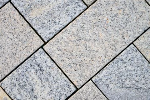 Close-up of a pavement made of rectangular and square stones of different s.. Stock Photos