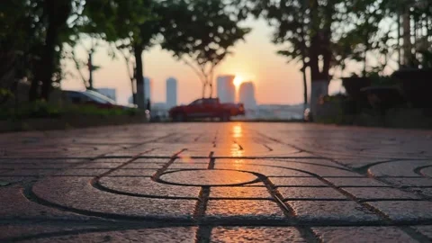 Close up of pavement promenade sunset lit and dense traffic and Cityscape in the Stock Footage 342369818
