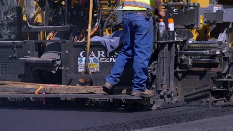 Close Up of Paver Laying Asphalt at Construction Site, real time Stock Footage