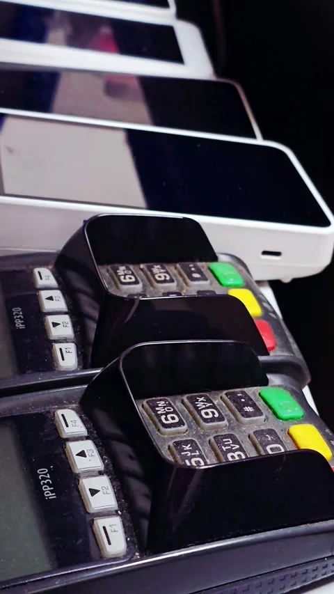 Close-up of payment terminals and mobile devices lined up on a counter, ready Video stock 345930068