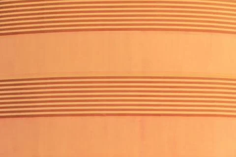 A close-up of a peach-colored wall with evenly spaced horizontal stripes in.. Stock Photos