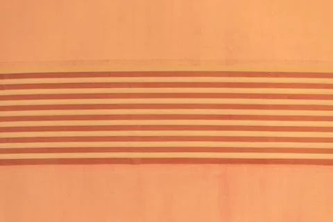 A close-up of a peach-colored wall with evenly spaced horizontal stripes in.. Stock Photos