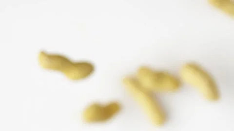 Close-up peanuts fly up on the white background slow motion, slow motion food Vídeo Stock 148552472