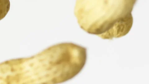 Close-up peanuts fly up on the white background slow motion Video stock 148552584