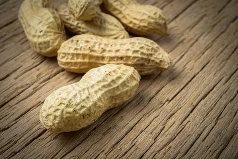 Close up peanuts in shells on wood background Stock Photos