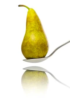 Close up of a pear, standing on a spoon with reflection, isolated on white Stock Photos