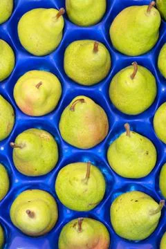 Close up of pears in blue plastic tray at local market Stock Photos