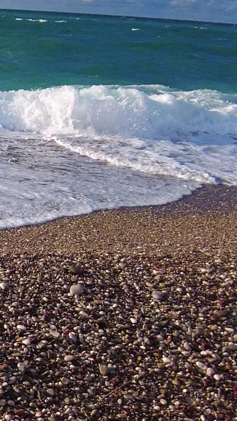 Close-up pebble beach waves in Antalya Video stock 323589314