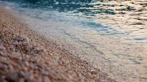 Close-up pebble stones beach at sunset. Видео 75343913