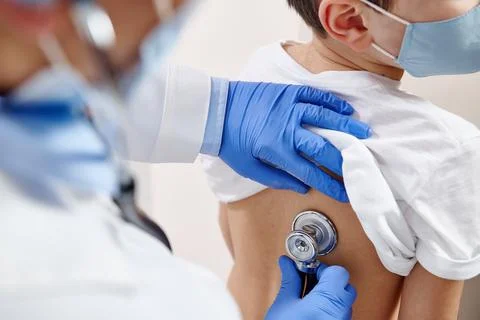 Close up of pediatrician using stethoscope, checking up heartbeat and lungs w Stock Photos