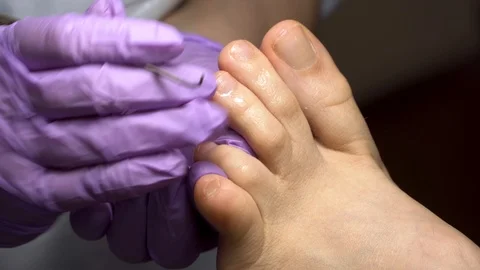 Close up pedicure process. Master working with cuticle remover. beauty salon. Stock Footage 102779878