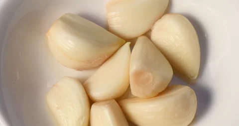 Close up of peeled garlic on a dish Stock Footage 162619313