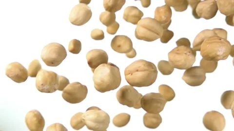 Close-up of peeled hazelnuts falling and spinning on white background Stock Footage 133925648