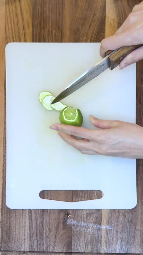 Close Up of Peeling and Cutting Fresh Lime on Cutting Board-Vertical Stock Footage 333788866