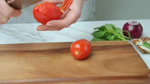 Close-up of peeling from skin tomatoes with a knife on a cutting board in 4K. Stock Footage 142672553