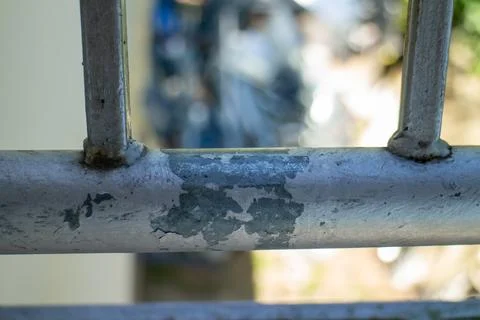 Close-up of peeling white paint on an old metal balcony railing outdoors Stock Photos