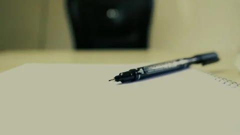 Close-up of a pen on a blank notebook page with blurred background Stock Footage 320724837