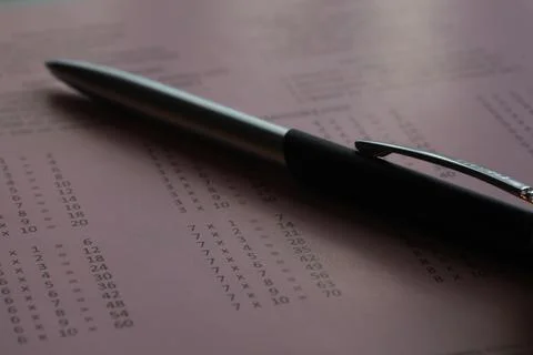 Close-Up of Pen on Pink Exam Answer Sheet with Mathematical Calculations Stock Photos