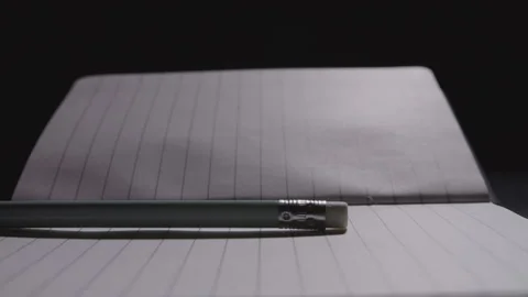 Close up of a pencil being laid down on an open notebook Stock Footage 332728681